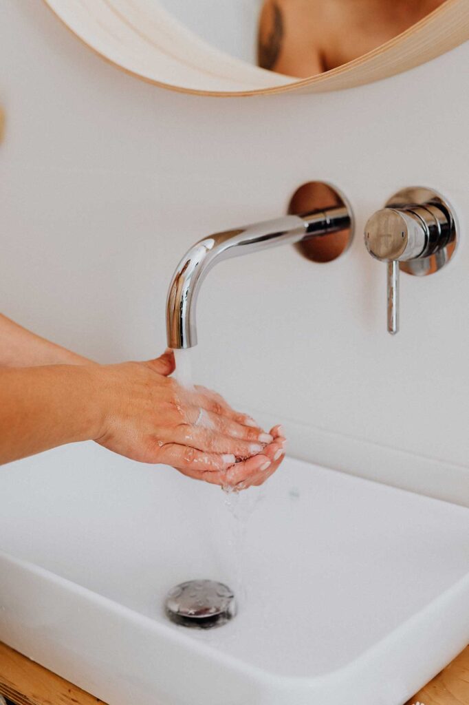 Lady washing her hands at a sink